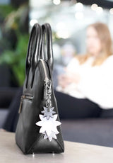 Lasessor Edelweiss heijastin - musta hopea - kukka - koruheijastin - laukkukoru - asusteet - IHANA Store